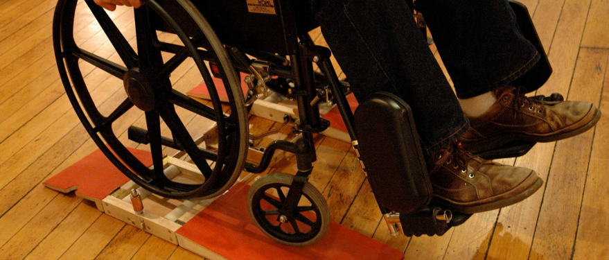 Ramps wheelchair DJ interface. A manual wheelchair sits on top of a roller system with red ramps.