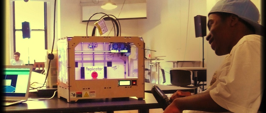 Young teen sitting in front of Makerbot 3D printer